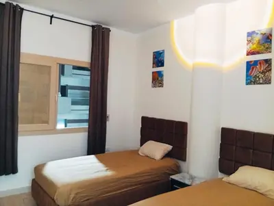 a bedroom with two beds and a window at شارع عربيه ع البحر مول السلام أمام مستشفي السلام in Hurghada