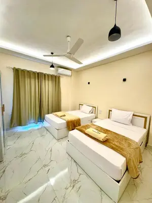 two beds in a hotel room with marble floors at Royal Nile Villa - Luxury Nile Sky Penthouse 1 in Al Aqālitah