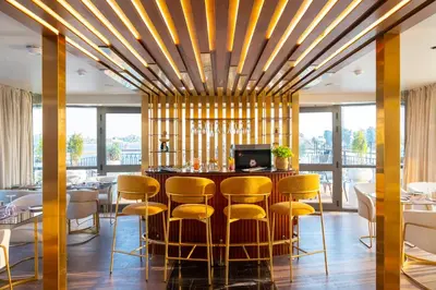 a dining room with a bar with yellow stools at Sonesta Dahabeya Amirat II - Nile Cruise Ship From Luxor to Aswan 4 nights in Luxor