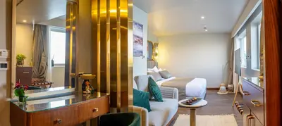 a hotel room with a bed and a living room at Sonesta Dahabeya Amirat II - Nile Cruise Ship From Luxor to Aswan 4 nights in Luxor
