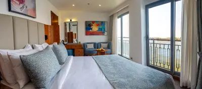 a bedroom with a bed and a large window at Sonesta Dahabeya Amirat II - Nile Cruise Ship From Luxor to Aswan 4 nights in Luxor