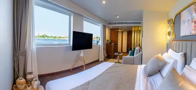 a bedroom with a large bed and a large window at Sonesta Dahabeya Amirat II - Nile Cruise Ship From Luxor to Aswan 4 nights in Luxor