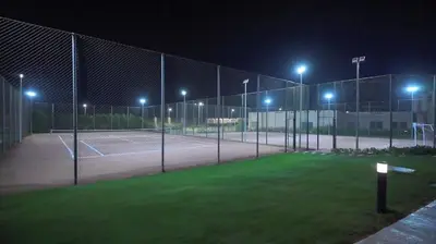 a tennis court at night with lights on at Oyster Bay Beach Suites in Marsa Alam