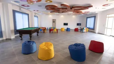a room with a pool table and some chairs at Oyster Bay Beach Suites in Marsa Alam