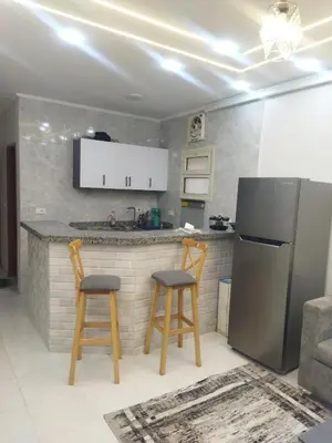 a kitchen with two bar stools and a refrigerator at Hurghada city apartments 5 in Hurghada