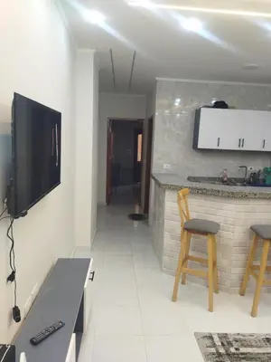 a living room with a tv and a table and chairs at Hurghada city apartments 5 in Hurghada