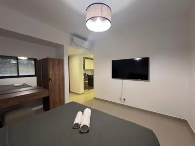 a room with a table with a tv and two shoes at Modern Studio in G-Cribs El Gouna in Hurghada