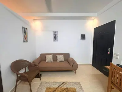 a living room with a brown couch and a black door at Home 2 Bedroom in Hurghada in Hurghada