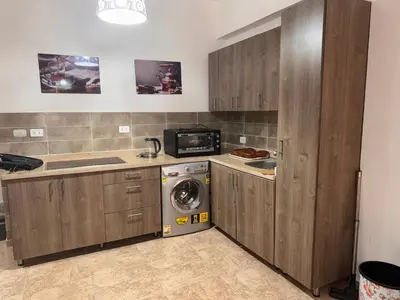 a kitchen with wooden cabinets and a washer and dryer at Modern 1bedroom in Hurghada in Hurghada