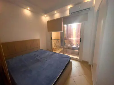 a small bedroom with a bed and a window at Cozy Studio in Hurghada in Hurghada