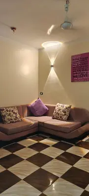 a living room with a couch with pillows on it at Family apartment LUXOR in Jazīrat al ‘Awwāmīyah
