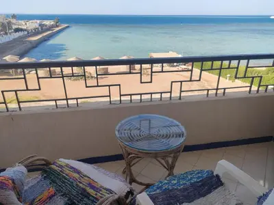 a balcony with a table and a chair and the ocean at Apartment Sama Beach in Hurghada