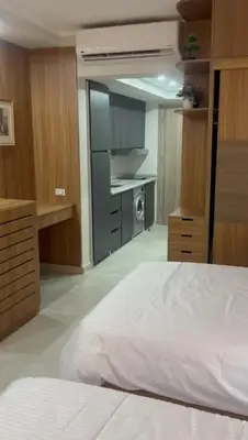 a bedroom with a white bed and a kitchen at Scandic resort in Hurghada