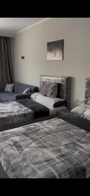 a room with two beds and a couch at غرفة فندقية in Hurghada
