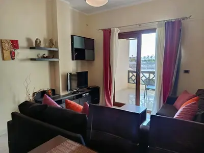 a living room with two couches and a television at Sahl Hasheesh Aparthotel Beachfront - SAHLHOMES in Hurghada