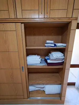 a wooden cabinet with some folded towels in it at Sahl Hasheesh Aparthotel Beachfront - SAHLHOMES in Hurghada