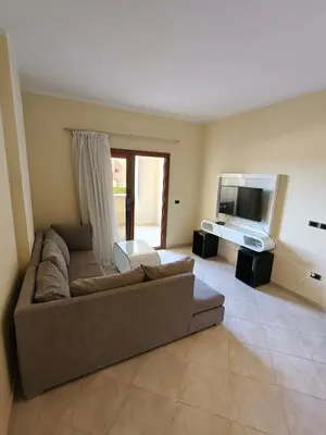 a living room with a couch and a television at Sahl Hasheesh Aparthotel Beachfront - SAHLHOMES in Hurghada