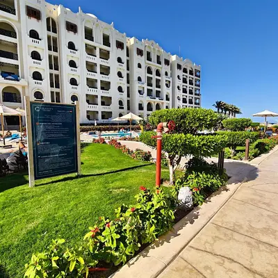 a large white building with a sign in front of it at Sahl Hasheesh Aparthotel Beachfront - SAHLHOMES in Hurghada