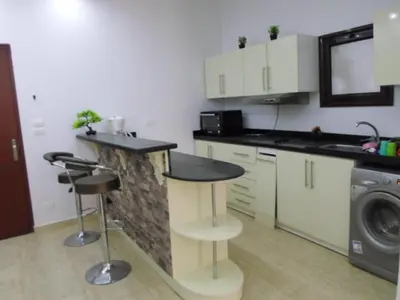 a kitchen with a counter and a sink and a stove at Hurghada Seafront Family Apartment with Pool View in Hurghada