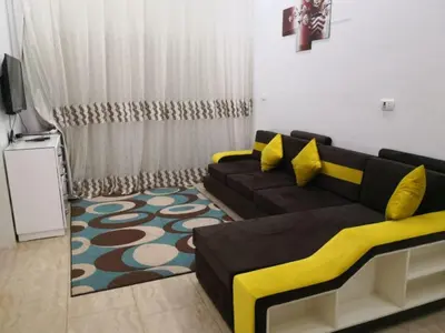 a living room with a couch and a television at Hurghada Seafront Family Apartment with Pool View in Hurghada