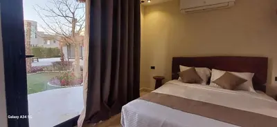 a bedroom with a bed and a large window at Luxury suit with private beach and aquapark in Hurghada