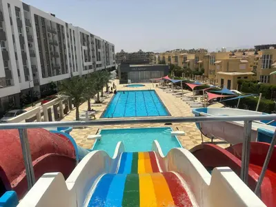 a view of a swimming pool with a rainbow slide at Luxury suit with private beach and aquapark in Hurghada