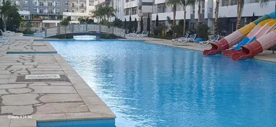a swimming pool with a water slide in a city at Luxury suit with private beach and aquapark in Hurghada