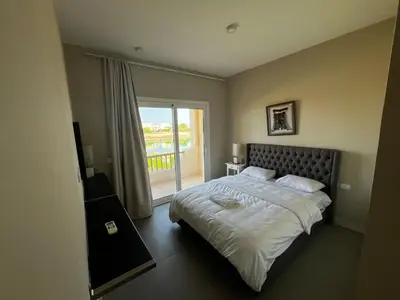 a bedroom with a large bed and a balcony at El Gouna Joubal Villa #2 with Private Garden and Lagoon View in El Gouna