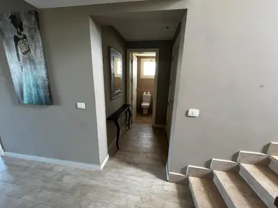 a hallway with stairs leading to a bathroom with a toilet at El Gouna Joubal Villa #2 with Private Garden and Lagoon View in El Gouna
