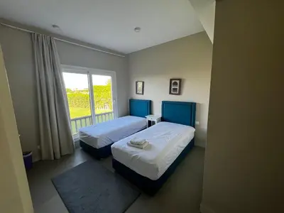 a bedroom with two beds and a window at El Gouna Joubal Villa #2 with Private Garden and Lagoon View in El Gouna