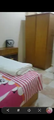 a bedroom with a bed and a wooden cabinet at الغردقه الوفاء in Hurghada