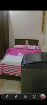 a bedroom with a bed with pink sheets and a suitcase at الغردقه الوفاء in Hurghada