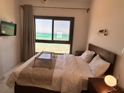 a bedroom with a bed with a view of the beach at Cozy 1-Bedroom Chalet with Sea View in Hurghada
