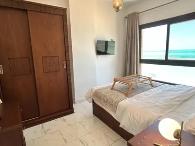 a bedroom with a bed and a large window at Cozy 1-Bedroom Chalet with Sea View in Hurghada