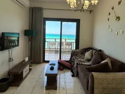 a living room with a couch and a view of the ocean at Cozy 1-Bedroom Chalet with Sea View in Hurghada