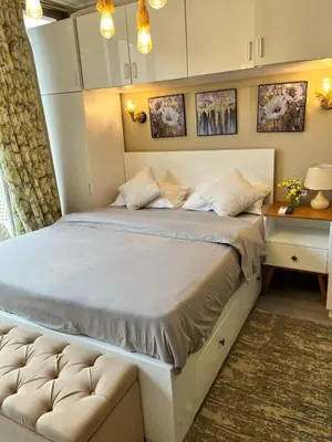 a large bed in a room with a nightstand and a bed sidx sidx sidx at استوديو أنيق في الجونة in Hurghada