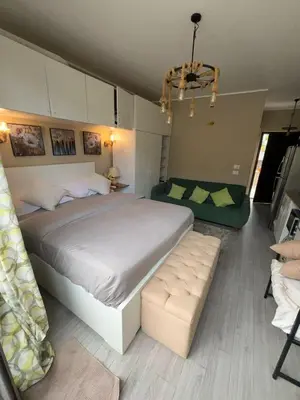 a bedroom with a large bed and a couch at استوديو أنيق في الجونة in Hurghada