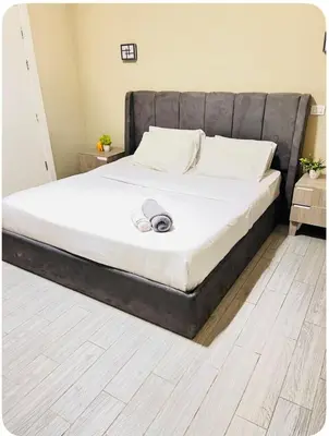 a bed with a black headboard in a bedroom at شاليه بالي بمسبح خاص مدفأ in Hurghada