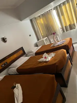 a hotel room with three beds with towels on them at Oscar Hotel Aswan \u4e2d\u570b\u4eba\u4e4b\u5bb6 in Aswan