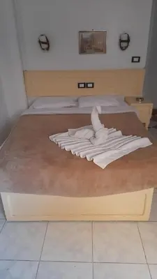 a bed with a pile of white towels on it at Oscar Hotel Aswan \u4e2d\u570b\u4eba\u4e4b\u5bb6 in Aswan