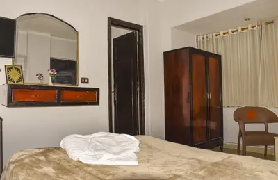 a bedroom with a bed with a mirror and a dresser at Oscar Hotel Aswan \u4e2d\u570b\u4eba\u4e4b\u5bb6 in Aswan