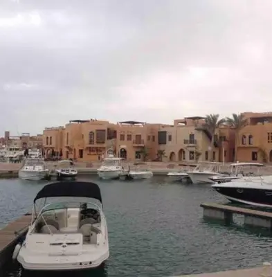 a boat is docked in a harbor with buildings at استوديوا بالجونه in Hurghada