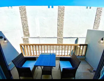 a balcony with a blue table and chairs in front of a window at استوديوا بالجونه in Hurghada