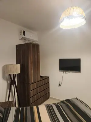 a bedroom with a bed and a flat screen tv at Arabian Suites by Imperial 1 bed Apartment in Hurghada