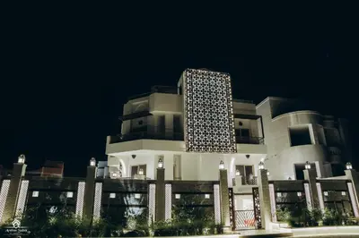 a large white building at night with a dark sky at Arabian Suites by Imperial 1 bed Apartment in Hurghada