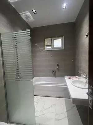 a bathroom with a tub and a sink at Jasmine Villa in Jazīrat al ‘Awwāmīyah