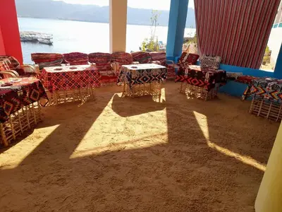 a group of tables and chairs in a room with the ocean at ISIS Hostel in Aswan