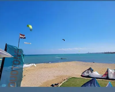 a beach with a kite flying over the ocean at Selena bay 006 in Hurghada