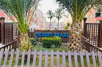 a sign for a desert pearl resort in front of a fence at Desert Pearl Studio Retreat in Hurghada