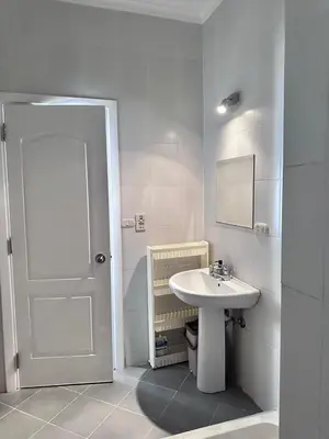 a white bathroom with a sink and a door at Desert Pearl Studio Retreat in Hurghada